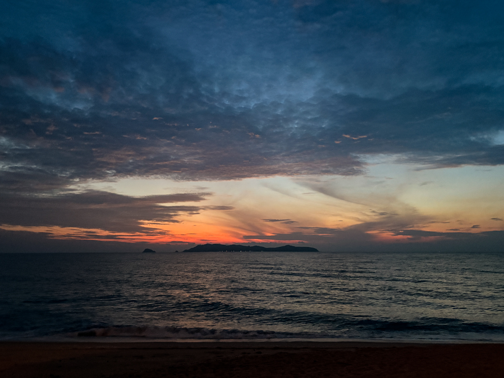 The sun rises behind Pulau Kapas, an island in Malaysia