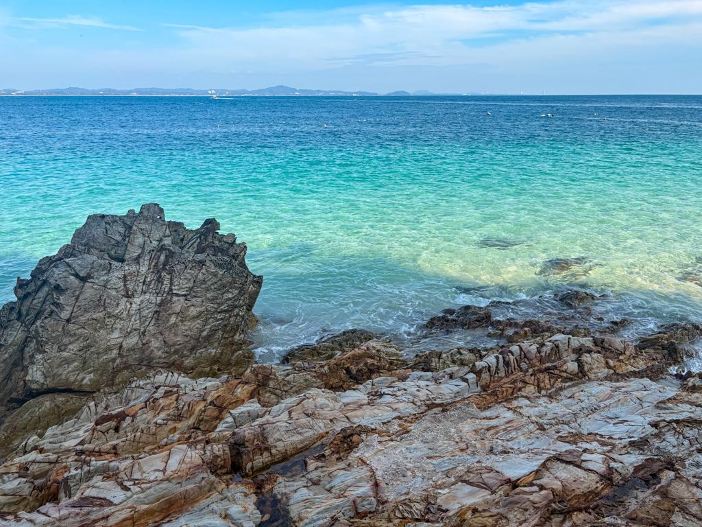 Bright blue and turquoise water behind an outcropping of rocks